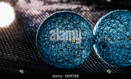 Two spheres from black fibers with mystery light. Touch of blue balls with bokeh on background. Science fiction, fantasy, technology or industry idea. Stock Photo