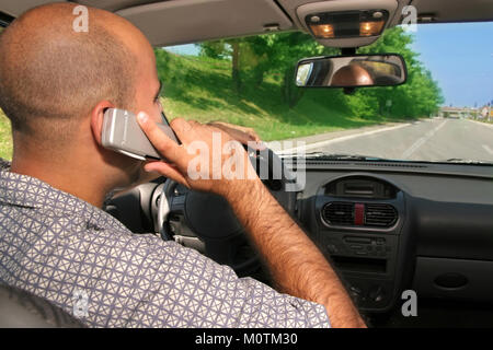Young adult hold mobil phone during driving Stock Photo