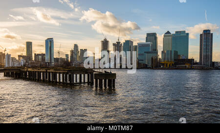 Modern skyscrapers of Canary Wharf with old overgrown pier and Thames in foreground, January 2018, Greenwich London Stock Photo