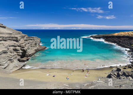 Papakolea or Green Sand Beach near South Point attracts hikers to lounge on the olivine beach in Hawaii. Stock Photo