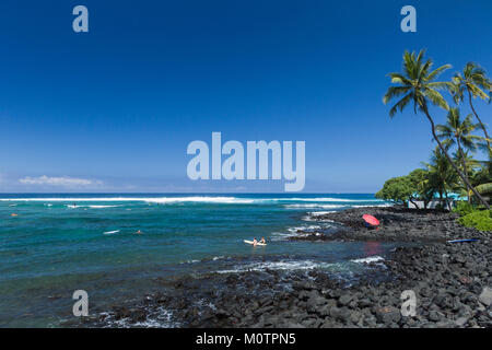 Surfers at Kahaluu Bay in Kailua Kona, Hawaii Stock Photo