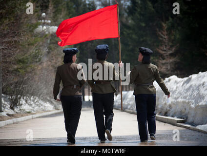 North Korean students with a red flag walking on the steps of the nation's heroes in mount Paektu, Ryanggang Province, Samjiyon, North Korea Stock Photo