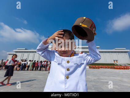 North Korean boy in army uniform putting his kepi in Grand monument of Mansu hill, Pyongan Province, Pyongyang, North Korea Stock Photo