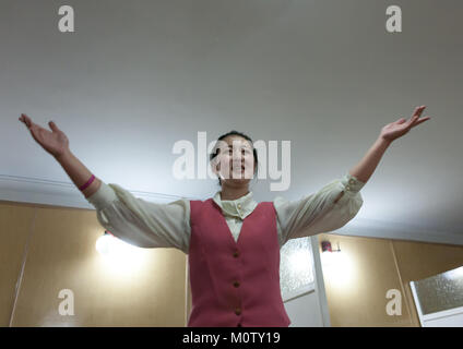 North Korean waitress in a restaurant singing for the tourists, Pyongan Province, Pyongyang, North Korea Stock Photo