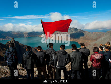 Group of students with red flag in front of lake at mount Paektu, Ryanggang Province, Mount Paektu, North Korea Stock Photo