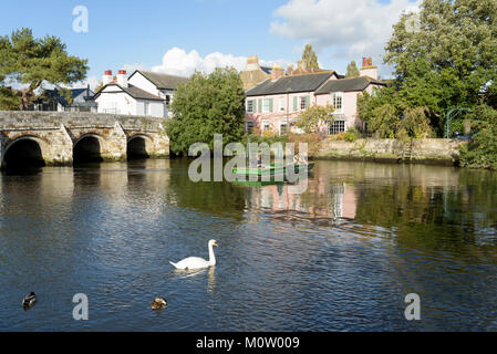 Two men in a boat fish on the river Avon in Christchurch, Dorset, England Stock Photo