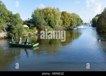 Two men in a boat fish on the river Avon in Christchurch, Dorset, England Stock Photo