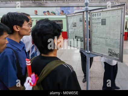 North Korean people reading the offical state newspaper in a subway station, Pyongan Province, Pyongyang, North Korea Stock Photo