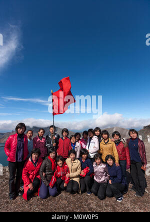 Group of students with red flag in front of lake at mount Paektu, Ryanggang Province, Mount Paektu, North Korea Stock Photo