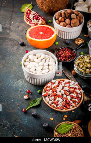 Set of organic healthy diet food, superfoods - beans, legumes, nuts, seeds, greens, fruit and vegetables. Dark blue background copy space Stock Photo