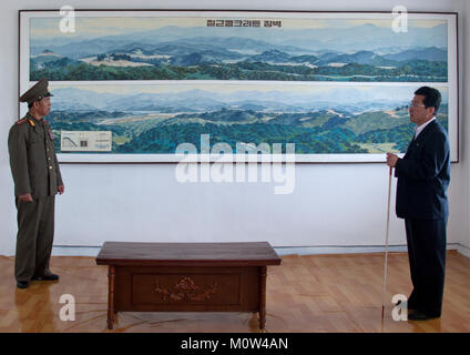 North Korean colonel and a guide in front of the map of the Demilitarized Zone wall area, North Hwanghae Province, Panmunjom, North Korea Stock Photo