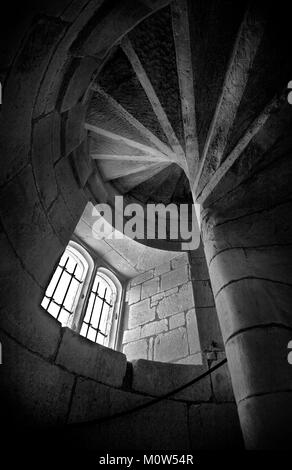 A window lit timeless image, looking up a stone spiral staircase inside 14th century Wardour Castle near Tisbury in Wiltshire. Stock Photo