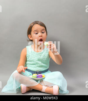excited little girl with a plate full of macaroons Stock Photo