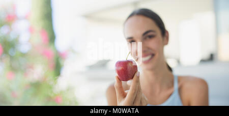 Portrait smiling brunette woman holding red apple Stock Photo