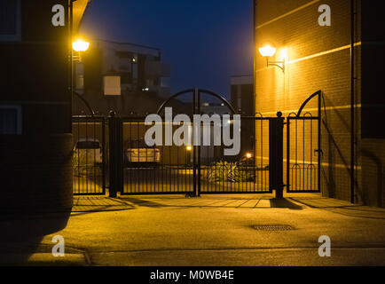 Gates and movement sensitive security lights at the entrance to a private car park in the UK. Stock Photo