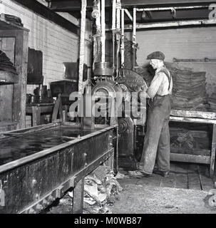 1950s, historical picture of a male worker at a tyre factory making ...