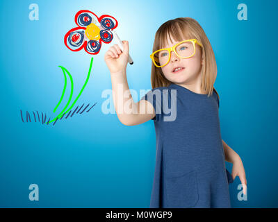 Cute little girl in yellow glasses draws a flower. Horizontal Stock Photo