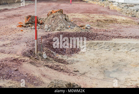 Excavation pit with sand and gravel and rod for height measurement Stock Photo