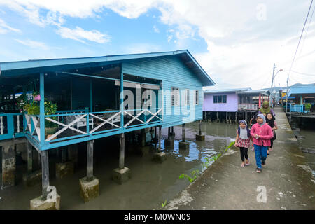 Young Muslim family walking in Sim Sim Water Village, the fishermen's village on stilts on the Heritage Trail, Sandakan, Sabah, Borneo, Malaysia Stock Photo