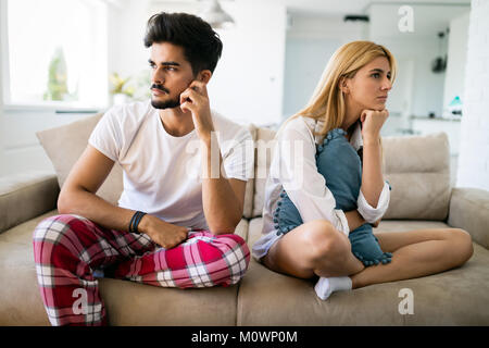 Worried couple having problems in bedroom Stock Photo