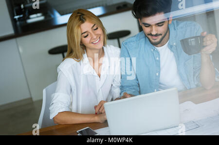 Photo of cheerful loving young couple using laptop Stock Photo