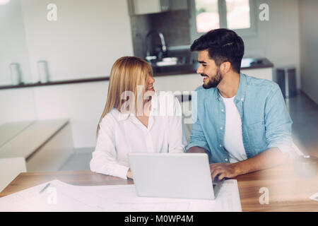 Photo of cheerful loving young couple using laptop Stock Photo