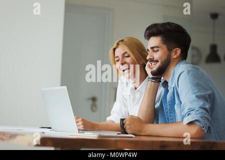 Handsome young man and attractive woman working on laptop Stock Photo