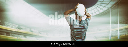 Composite image of rear view of sportsman throwing rugby ball Stock Photo