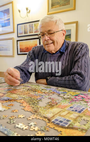 OLDER MAN WORKING ON A JIGSAW UK Stock Photo