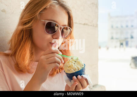 European teenage girl in sunglasses eats fruit ice cream, closeup outdoor portrait Stock Photo