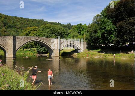 Belgium,Luxembourg,Bouillon,Cordemoy bridge or pulley bridge on the Semois,two people dipping their feet in the water Stock Photo