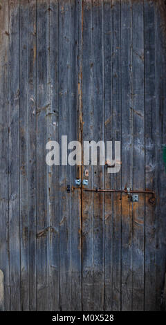 Wooden dark blue, blank, aged, peeled door for backdrop. Rusty latch on doorway. Close up, banner. Stock Photo