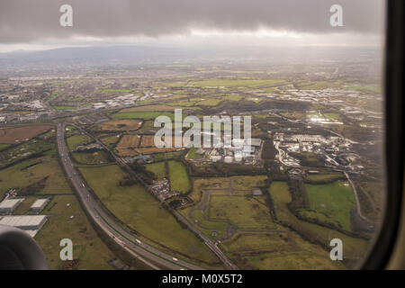 View over the M50 motorway in Dublin through the porthole window of a plane just after departing Dublin airport, on a wet winters day, Ireland Stock Photo