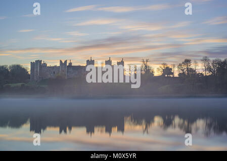 Framlingham castle in Suffolk at sunrise, reflected on the water Stock Photo