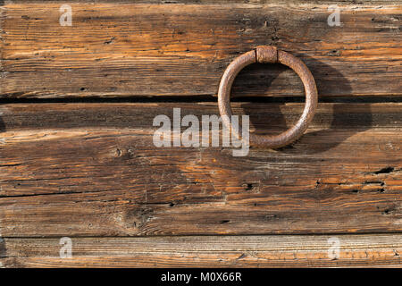 rusty metallic door ring over ancient dark wooden planks Stock Photo