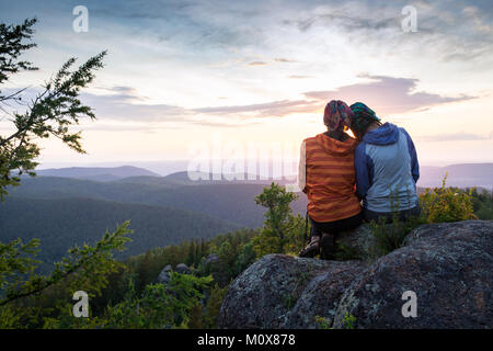 Couple Watching Sunset Mountain Outdoors Concept Stock Photo