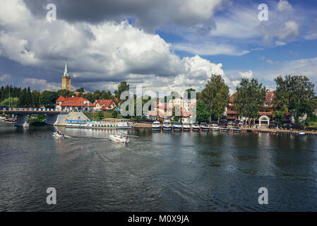 View from footbridge over Talty Lake in Mikolajki in Warmian-Masurian Voivodeship of Poland. Evangelical Holy Trinity Church on background Stock Photo