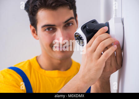 Contractor installing surveillance CCTV cameras in office Stock Photo