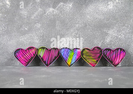 Homemade Black violet pink hearts on a gray concrete background. The concept of Valentine's Day. A symbol of love Stock Photo