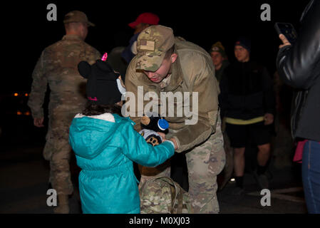 Staff Sgt. Justin Stevenson, 436th Security Forces Squadron defender, hands a stuffed animal to his daughter, Julia, Jan. 21, 2018, at Dover Air Force Base, Del. Stevenson and 11 of his wingmen returned early that morning from a six-month deployment to the Middle East. (U.S. Air Force Stock Photo
