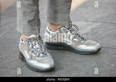 MILAN - JANUARY 13: Man with Lanvin silver and beige sneakers before Emporio Armani fashion show, Milan Fashion Week street style on January 13, 2018  Stock Photo
