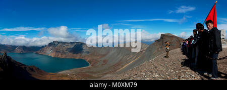 Group of students with red flag in front of lake at mount Paektu, Ryanggang Province, Mount Paektu, North Korea Stock Photo