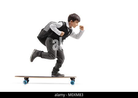 Full length profile shot of a schoolboy riding a longboard isolated on white background Stock Photo