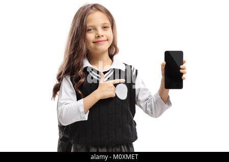 Little schoolgirl holding a phone and pointing isolated on white background Stock Photo