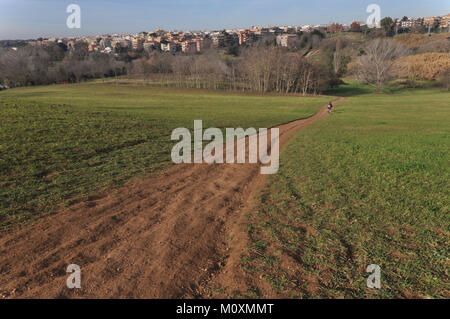 Dirt road in park of caffarella with buildings in the background Stock Photo
