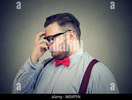 Young man rubbing forehead trying to solve difficult problem. Stock Photo
