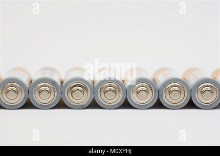 Row lying AA battery on white background with blurred background Stock Photo