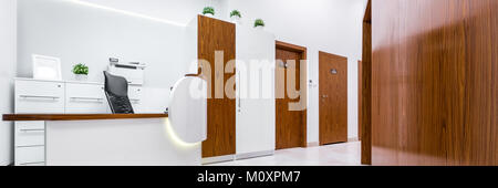 Panoramic view of modern reception in clinic with wooden doors and desk Stock Photo