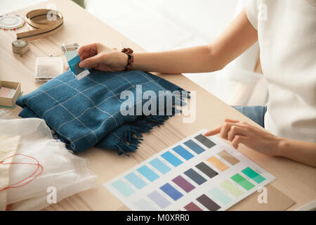 Female fashion designer holding samples choosing color working w Stock Photo