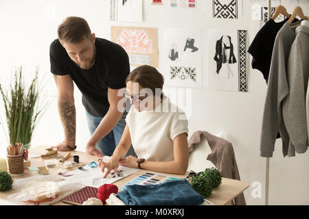 Two designers team discussing fashion sketches, teamwork in desi Stock Photo